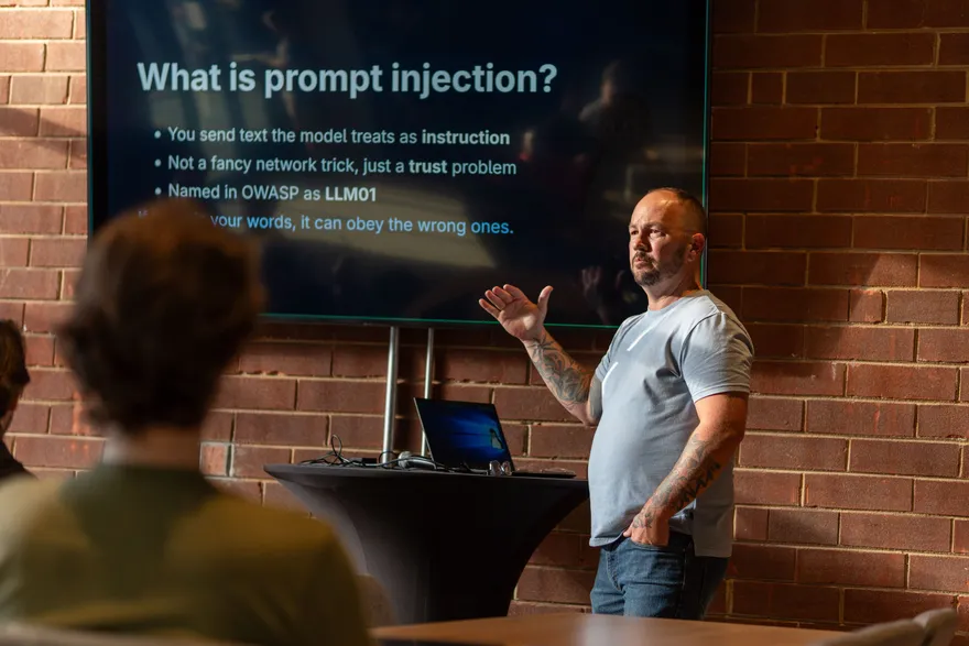 Brian Chastain presenting on prompt injection at DC704
